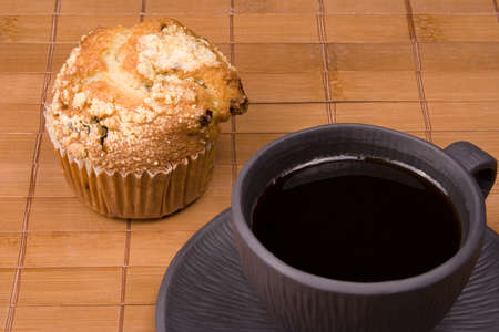 Coffee and muffin on a brown backgroundの写真素材