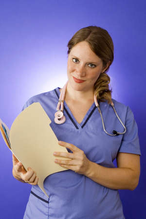 Young nurse on blue holding a folderの写真素材