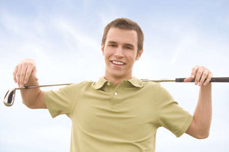 People against blue sky with golf clubsの写真素材