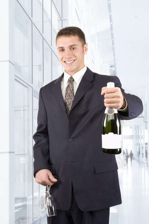 Attractive young man holding champagne and flutesの写真素材