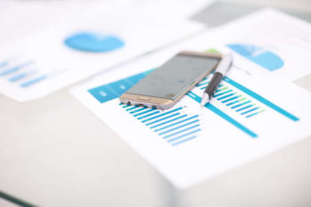 Financial close-up background. Financial accounting graphs, pen, phone.の写真素材