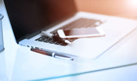 Closeup picture of a keyboard with a phone lying above itの写真素材