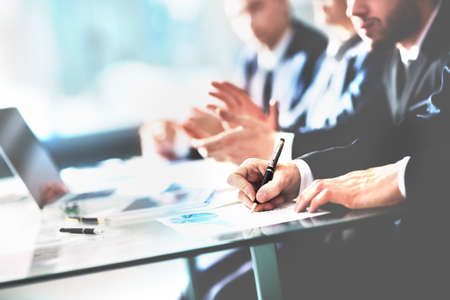 Close up of young business partners applauding to reporter after listening report at seminar. Professional education, work meetiの写真素材