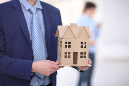 Two colleagues discussing data working and tablet, laptop with on on architectural project at construction site at desk in officeの写真素材