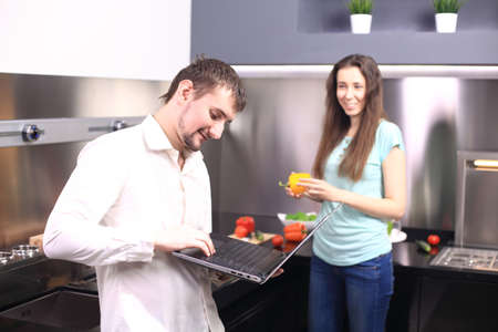 Couple in front laptop computer in the kitchen