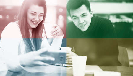 Happy couple using smartphone together and drinking coffee in cafeの写真素材