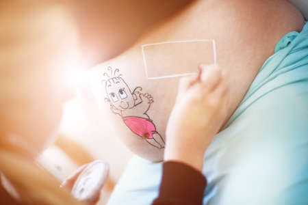 Close up of a cute pregnant belly with bearの写真素材