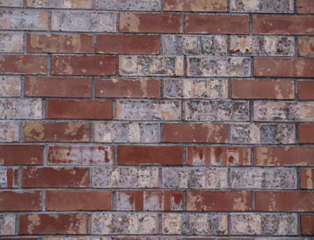 Brick wall close up with weathered, distressed red brick.  Landscape orientation.