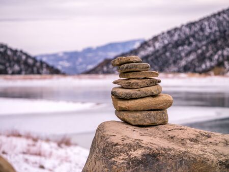 Rock cairn with frozen lake in background