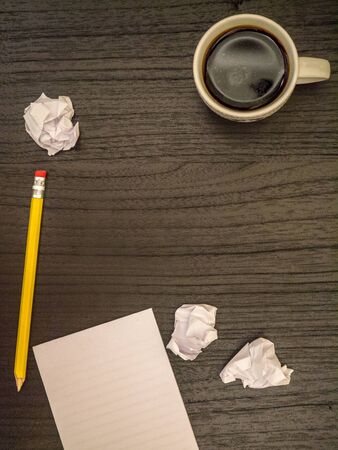 Dark surface, paper wads, pencil, coffee blackの写真素材