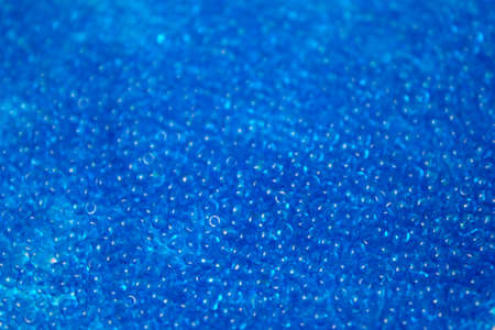 This is a closeup photograph of Blue Glass seed beads backgroundの写真素材
