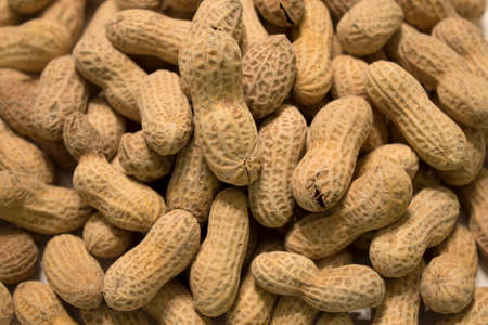 This is a photograph of salted and roasted peanuts in the shell