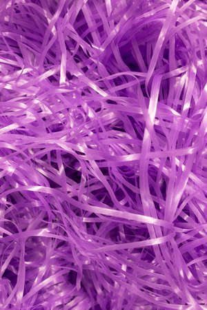 This is a photograph of Purple shredded plastic fake Easter grass background