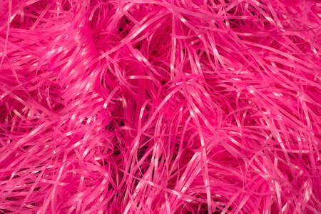 This is a photograph of Pink shredded plastic fake Easter grass background
