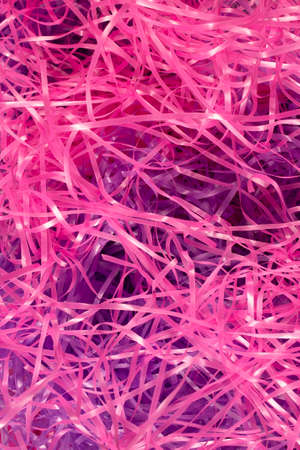 This is a photograph of Pink and Purple shredded plastic fake Easter grass background
