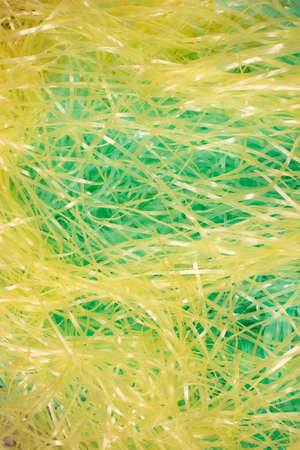 This is a photograph of Green and Yellow shredded plastic fake Easter grass background