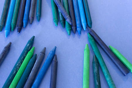 This is a photograph of Blue,Green and Purple crayons placed on colorful craft paperの写真素材