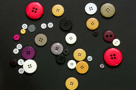 This is a photograph of colorful sewing buttons on a black background