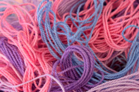 This is a photograph of Pastel Pink,Purple and Blue Cotton Embroidery threads backgroundの写真素材