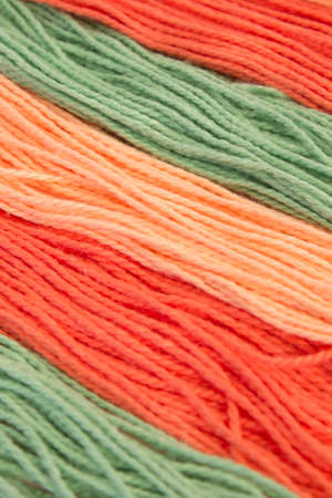 This is a photograph of Pastel Orange and Green Cotton Embroidery threads background