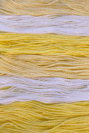 This is a photograph of Pastel Yellow and White cotton Embroidery threads background