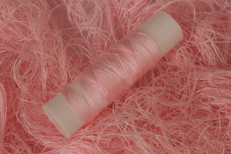 This is a photograph of Pastel Pink sewing thread roll background