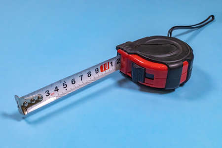 Tape-line is the most popular measuring device isolated on a blue background