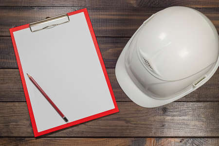 White hardhat and a pencil  illustrating construction mesurements