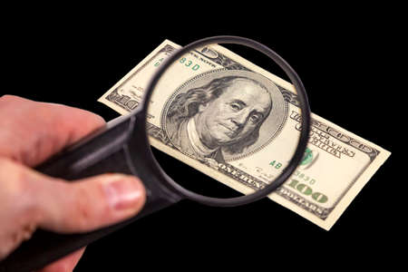 One hundred dollars banknote under close investigation. Concept illustrating financial relations.の写真素材