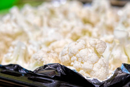 Pieces of cauliflower on a baking sheet (foil). Healthy food close-up.の写真素材