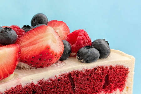 Traditional red velvet cake decorated with strawberries and blueberries