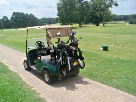 golf cart with bags near driving rangeの写真素材
