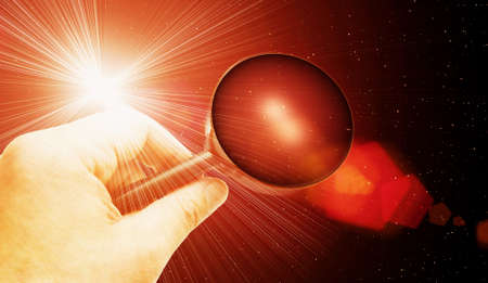hand with magnifying glass searching powerful lightの写真素材
