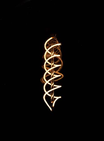 Luminous thread of a retro Edison lamp on a dark backgroundの写真素材