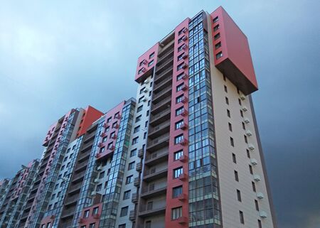 view of a modern new building with bright facades against a stormy sky