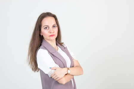 beautiful young woman in business strict clothes poses against a white wallの写真素材