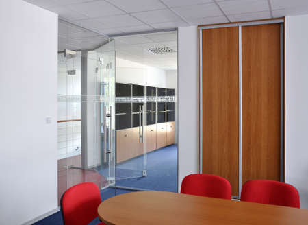 Meeting room with glass door, table and chairsの写真素材