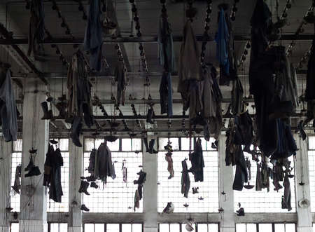 Locker room of an old industrial factory: Work clothes hanging from the ceilingの写真素材