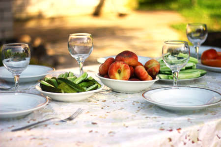 wingalsses and plates on a settle table outdoorの写真素材