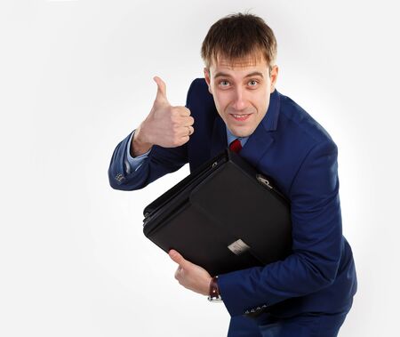 Successful businessman with a briefcase. Thumb upの写真素材