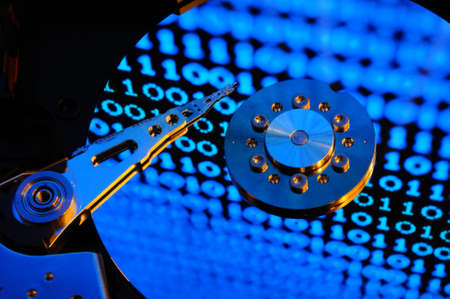Close up of Computer Hard Drive Disc with binary effects reflected on the disk surface. Background wallpaper.の写真素材
