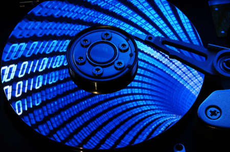 Close up of Computer Hard Drive Disc with binary effects reflected on the disk surface. Background wallpaper.の写真素材