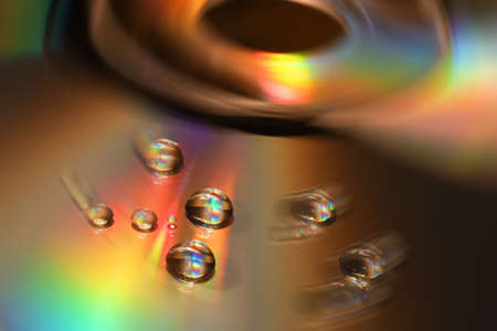 Water Drops on CD and DVD. Colorful background.