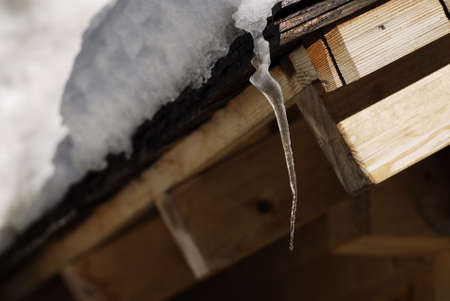 Icicles hanging from the roof of an alpine hut in Dolomites, Italy.の写真素材