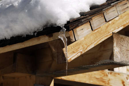 Icicles hanging from the roof of an alpine hut in Dolomites, Italy.の写真素材