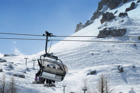 11 March 2009: skiers on a chairlift in the Italian Dolomites in Val Badia. San Cassiano, Italy.