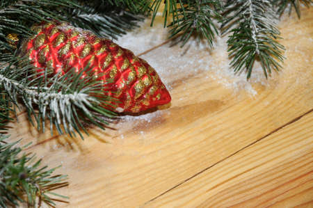 Snow-covered Christmas tree branch with Christmas balls on wooden background. Xmas backgroundの写真素材