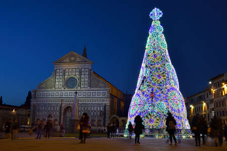 Florence, December 2018: Illuminated Christmas Tree in Santa Maria Novella Square with the Basilica on the background, on the occasion of the F-Light Festival of Lights, during the Christmas season 2018.のeditorial素材