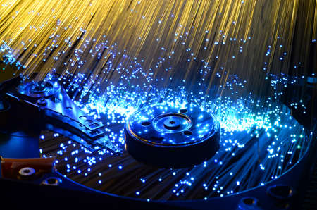 hard disk with colored fiber optics, tech background.の写真素材