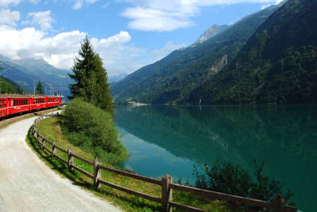 Switzerland, July 2012: Swiss Mountain Train Bernina Express at Lake of Poschiavo